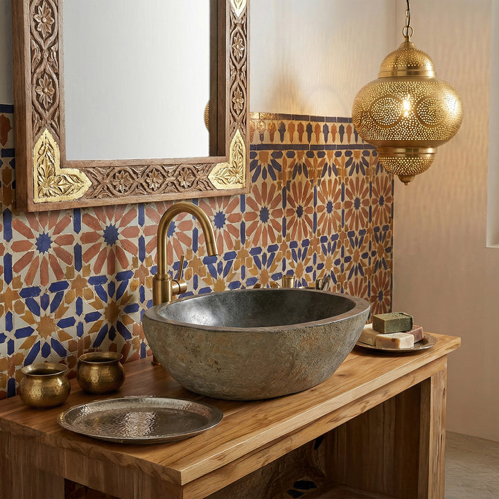 piedra de rio Lavabo en el baño oriental sobre una consola de madera, combinada con herrajes de latón, mosaicos y luz cálida