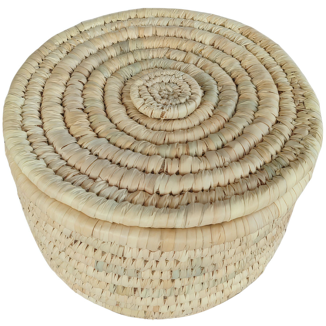 Cesta redonda de almacenamiento fabricada con hoja de palma, de 28 cm de diámetro y con tapa cerrada con un diseño en espiral.