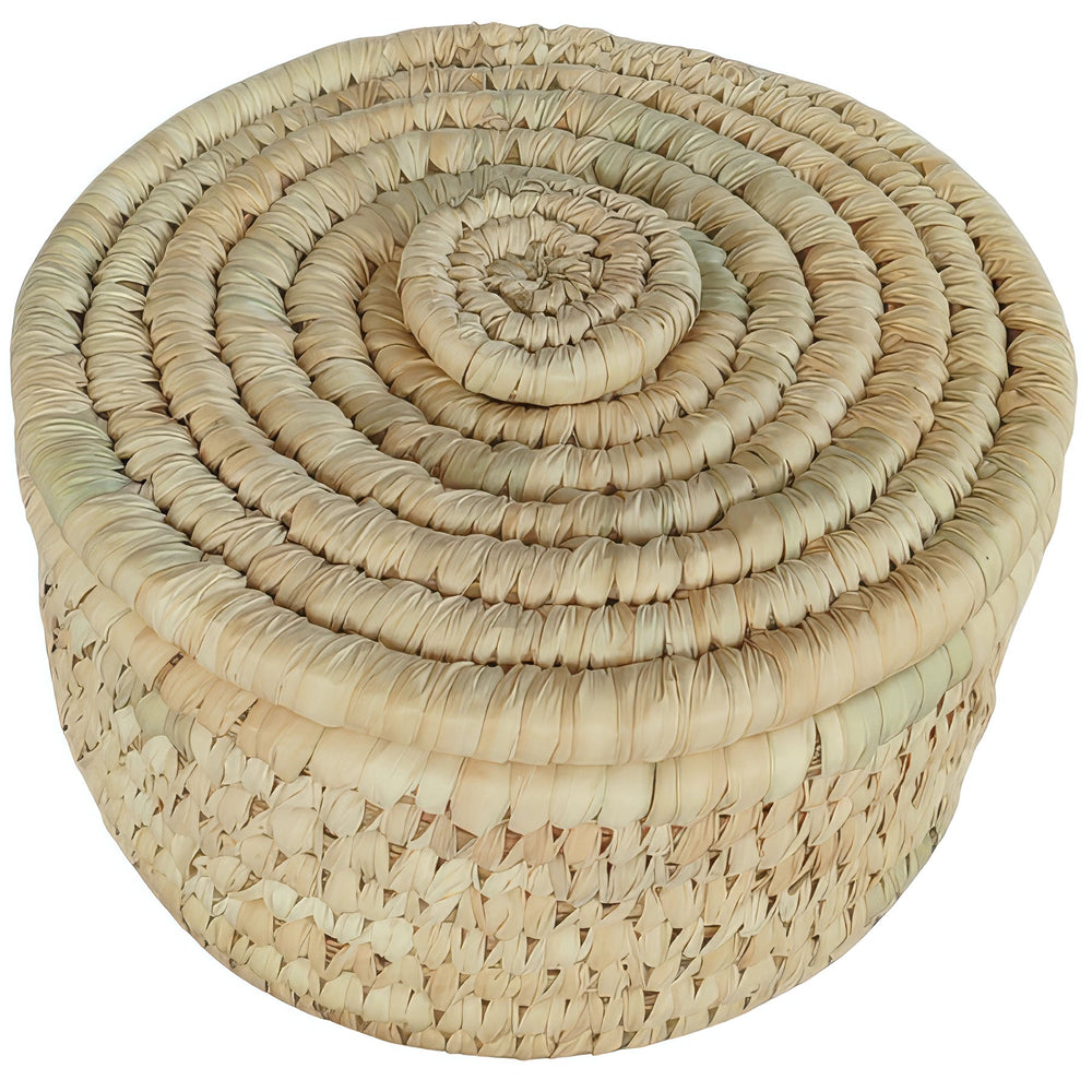 Cesta redonda pequeña de hojas de palmera con tapa cerrada de trenzado en espiral y tonos beige claro y pajizos.