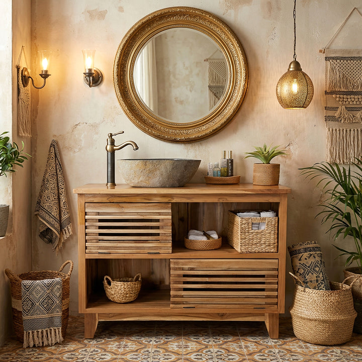 Lavabo sobre encimera de piedra de río en un cálido baño boho sobre un lavabo de madera, combinado con accesorios de latón, cestos y una luz suave