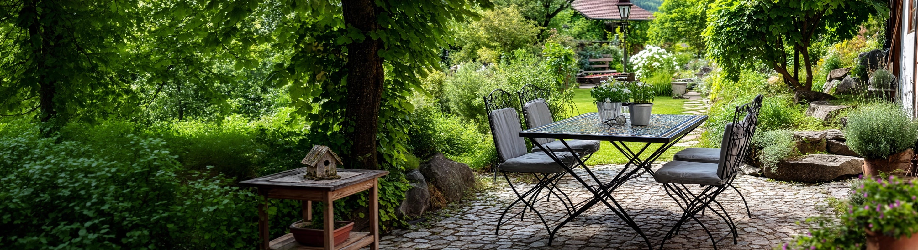 Jardín y terraza – Garten mit Mosaiktisch und Sitzgruppe auf Natursteinweg unter Bäumen – stilvoller Outdoor-Bereich für Terrasse und Gartenmöbel
