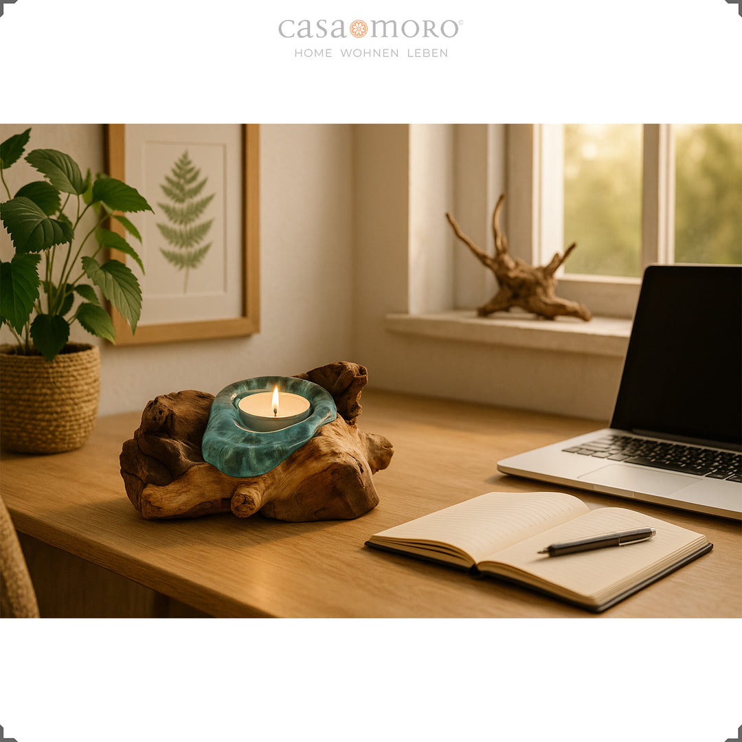 Teelichthalter aus Glas und Wurzelholz auf einem Schreibtisch, sein sanftes Licht bringt eine natürliche, entspannte Arbeitsatmosphäre.
