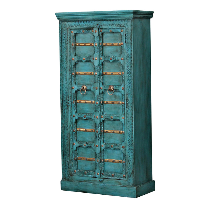 Armario turquesa de madera maciza de mango, con dos puertas ornamentadas y tiradores de anilla, en ángulo.