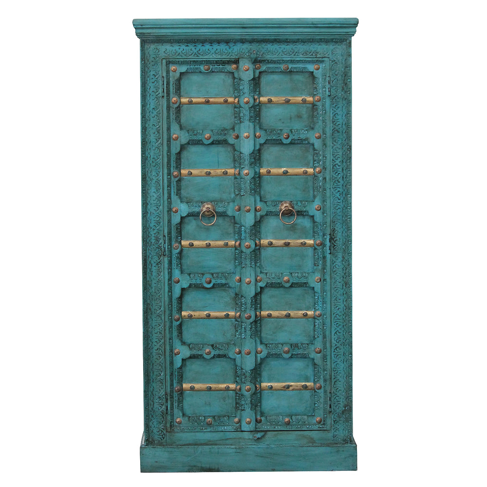 Vista frontal del armario turquesa con tallas decorativas, travesaños dorados y dos puertas de madera de mango.
