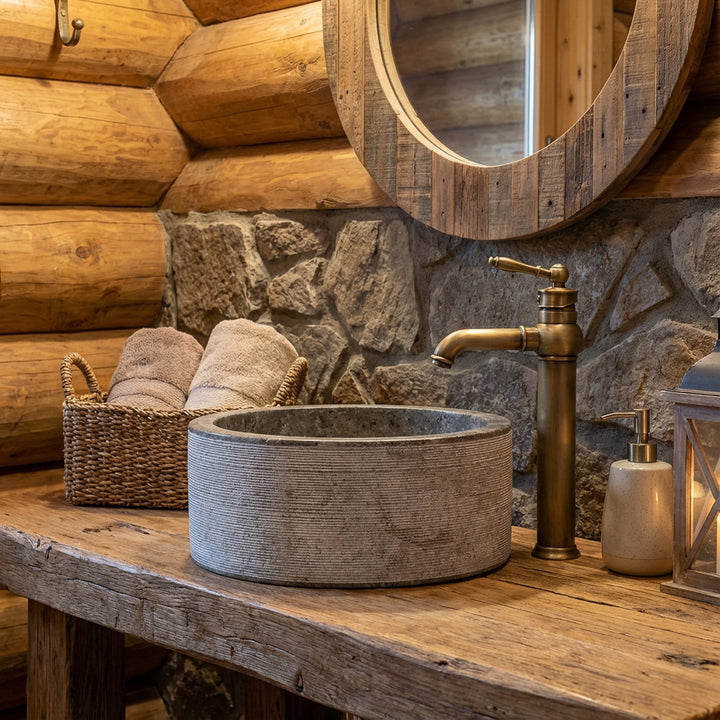 Mármol redondoLavabo sobre una consola de madera rústica con herrajes de latón en el acogedor baño del chalet, con una iluminación cálida.