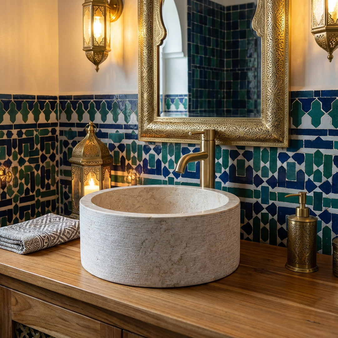 Mármol redondoLavabo sobre una consola de madera, ambientada en el baño oriental con mosaicos y detalles de latón.