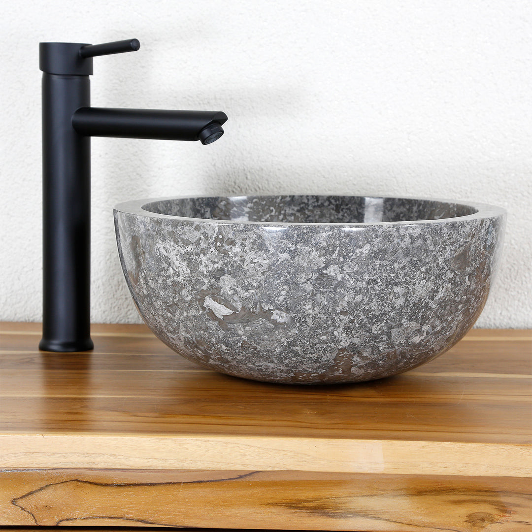 redondo Lavabo Fabricado en mármol gris con interior pulido, fregadero de piedra sobre tapa de madera con grifería.