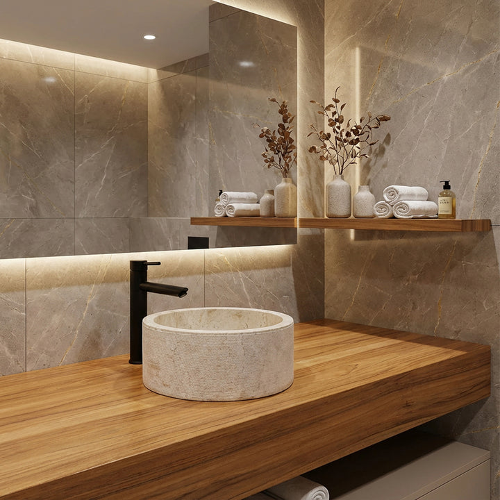redondo Lavabo de piedra natural sobre una elegante consola de madera, ambientada de forma moderna en el tranquilo baño con luz cálida.