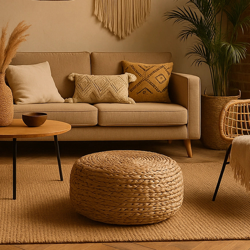 Sitzhocker aus handgeflochtenem Seegras in einem natürlichen Boho-Style Wohnzimmer mit warmen Erdtönen, Sofa, Pflanzen und Texturen