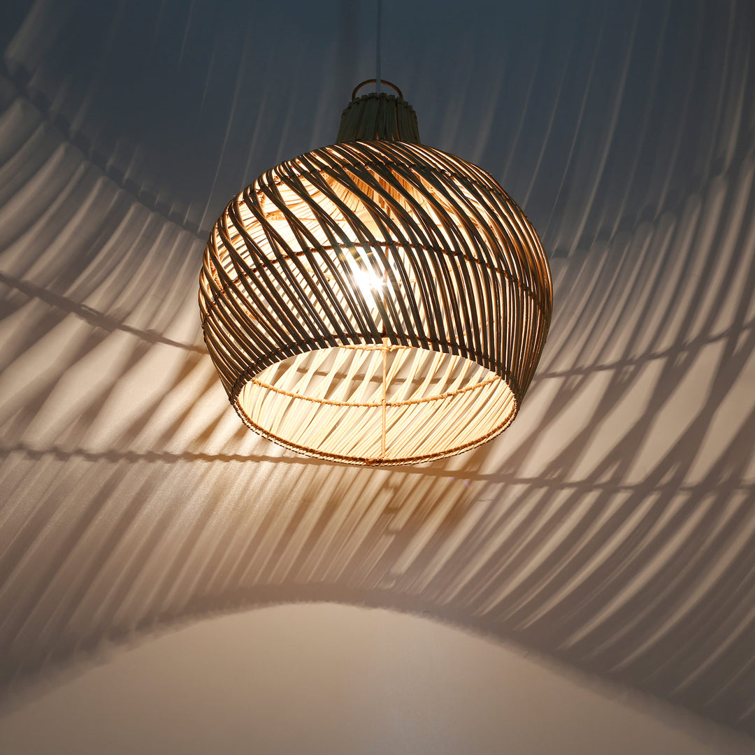 Beleuchteter Lampenschirm aus Rattan mit offenem Geflecht und eindrucksvollem Licht- und Schattenspiel an Wand und Decke