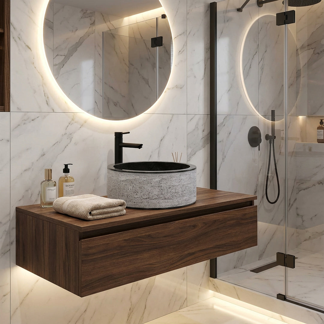 Lavabo redondo de piedra sobre consola flotante de madera, combinado de forma moderna con grifería negra en un elegante baño de diseño.