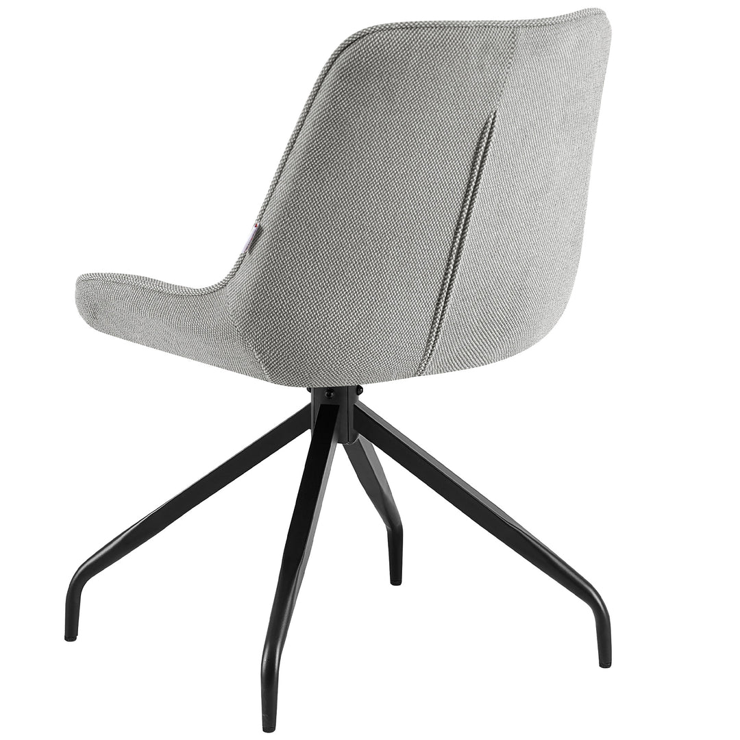 Grauer Esszimmerstuhl mit 360° Drehfunktion und schwarzem Metallgestell – gemütliche Leseecke mit Beistelltisch, Decke und warmem Licht