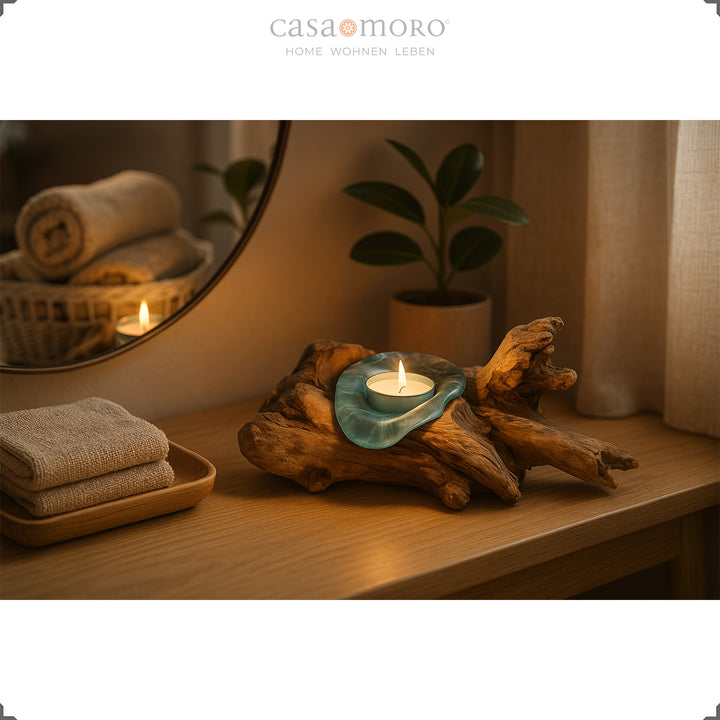 Teelichthalter aus Glas und Wurzelholz auf einer Konsole, sein warmes Kerzenlicht schafft eine sanfte, wohnliche Stimmung.