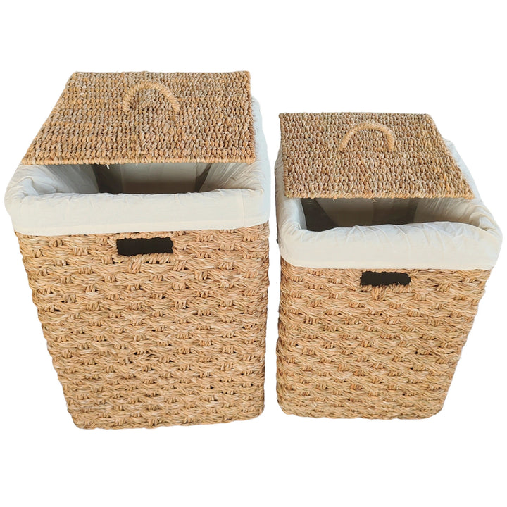 Cestas rectangulares para la ropa sucia fabricadas en algas marinas, en un juego de dos unidades, de aproximadamente 55 y 85 litros, con tapas elevadas e inserciones de tela en tonos claros.