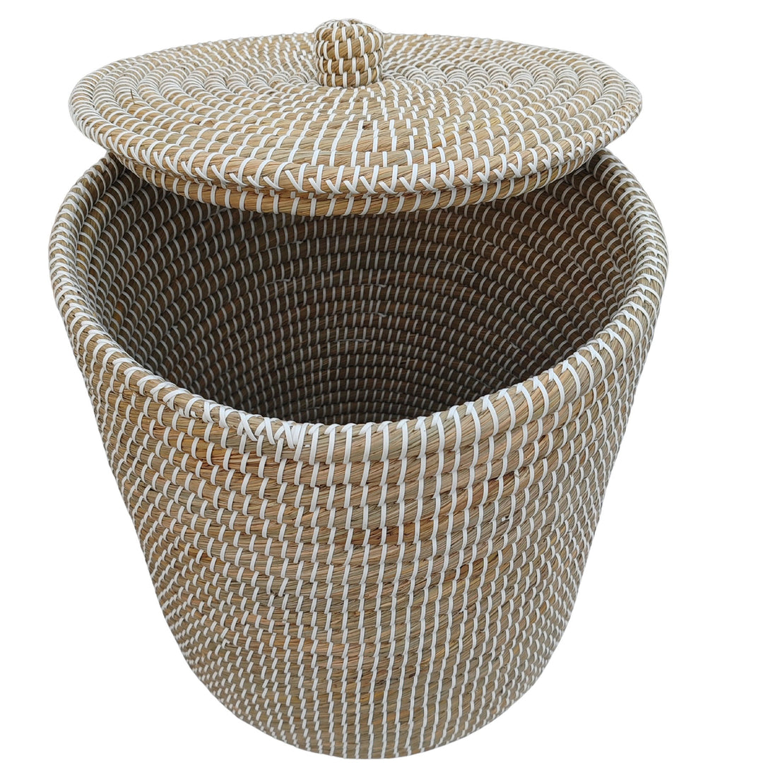 Cesto de la ropa abierto, fabricado con algas marinas, con un volumen aproximado de 65 litros y tapa elevada; vista interior.
