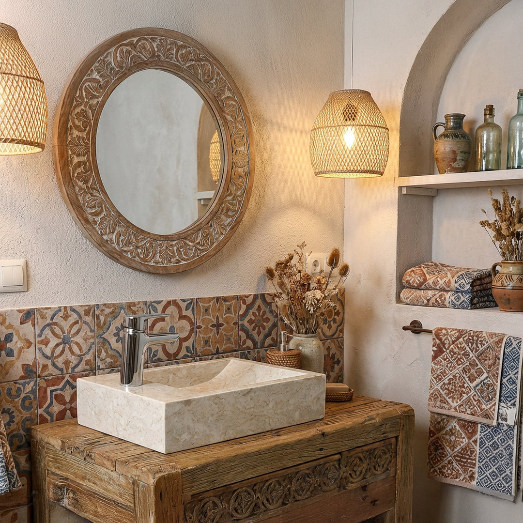 Lavabo sobre encimera rectangular de piedra natural clara sobre un lavabo de madera en un baño oriental con azulejos estampados y luz cálida